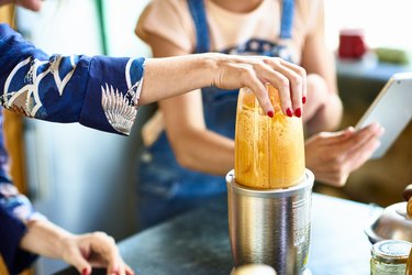 Woman preparing smoothie in blender