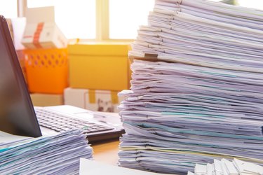 Close-Up Of Stacked Documents At Desk In Office