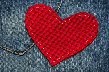 Red textured heart on jeans background