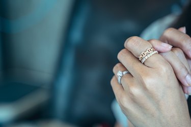 Close up of an elegant engagement diamond ring on beautiful Asian woman's finger