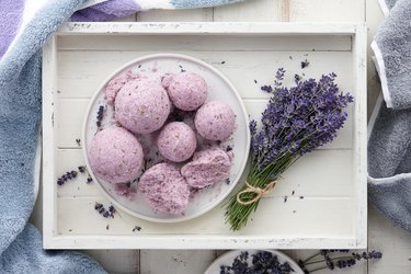 Handmade lavender bath bombs and flowers in white tray