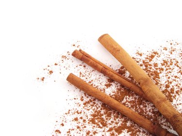 Cinnamon sticks with powder on white
