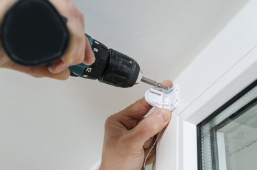 Installing roller blind on a window.