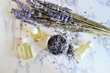 Aromatic oils with lavender flowers on marble background