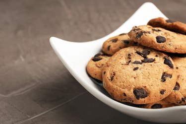 Plate with chocolate chip cookies on grey background, closeup