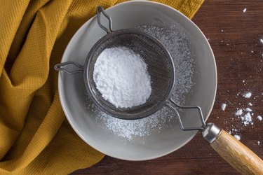 Directly Above Shot Of Powdered Sugar With Sieve On Table