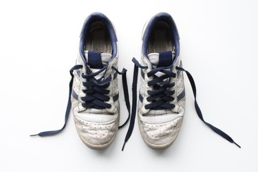 Pair of worn, white vintage sneakers shot from above