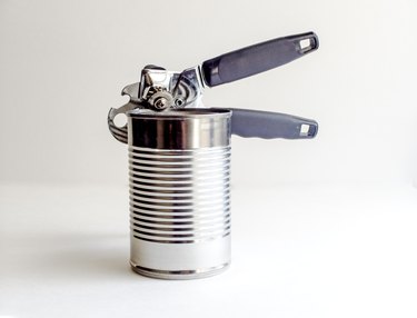 Aluminum Can And Opener Against White Background