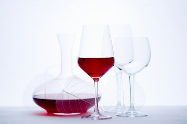 Glass of red wine, carafe and empty wine glasses, close-up