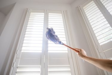 Cleaning the shutters with a feather duster