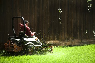 Working class.  Man mows lawn using industrial lawn mower.