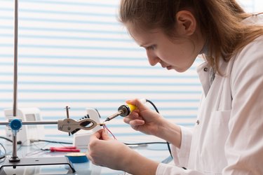 Girl Solder and adjust Electronic Device