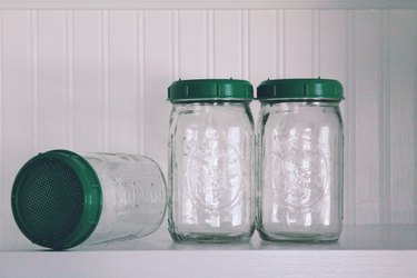 Mason jars with green lids on a shelf