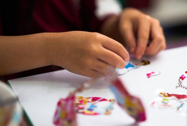 kid hands view ,playing sticker of cartoon toy