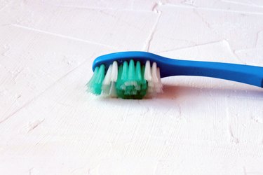 Used worn blue toothbrush on background. Selective soft focus. Text copy space.