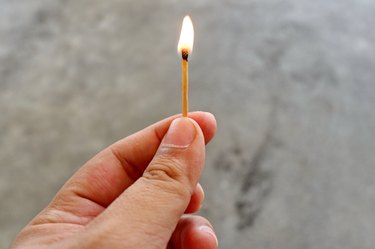 Cropped Hand Of Person Holding Lit Matchstick