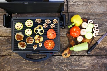 Grilled sausage and vegetables on the electric grill. Top view. Flat lay.