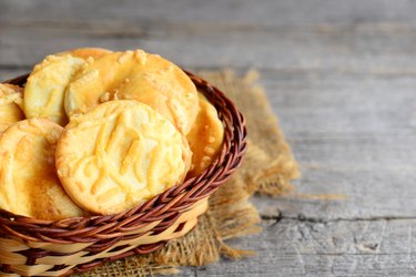 Crispy cheese cookies. Homemade baked cheese cookies in a wicker basket on a vintage wooden background. Closeup