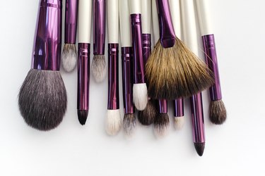 Set Of Makeup Artist Brushes For Professional Makeup In A Beauty Salon, On A White Background. The Concept Of Cosmetics, Body And Face Care.