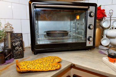 Cake pan inside a countertop oven, positioned diagonally in the corner