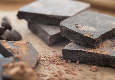 Chocolate oscuro con cacao en mesa de madera