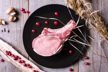 Fresh deer meat on black plate and wooden table