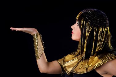 Person portraying Cleopatra on black background