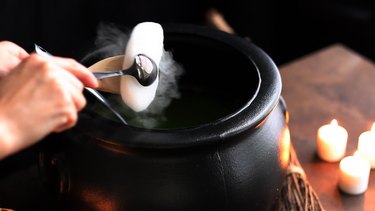 Placing dry ice inside black cauldron