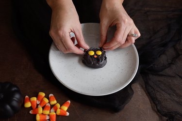 Yellow Reese's pieces placed on cookie as eyes and chocolate chips as ears