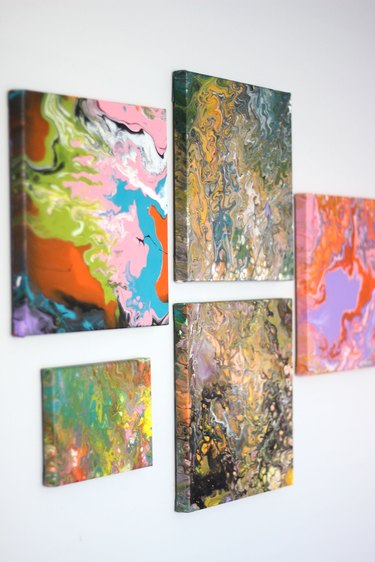 five completed paintings hanging on wall