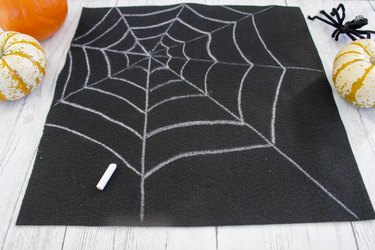 This not so itsy-bitsy spider DIY web pillow will create that spooky vibe you're going for.