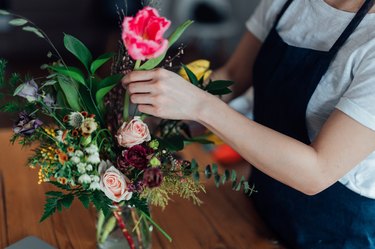 Cropped shot of young woman arranging fresh flowers at home