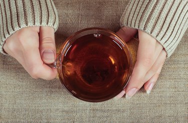 Woman holds cup of black tea
