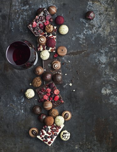 Glass of red wine and various chocolate truffles and sweets
