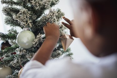 Boy Decorating Christmas Tree at Home