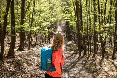 Woman with backpack hiking in forest
