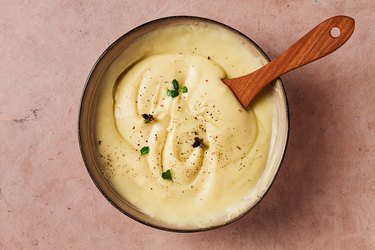 Mashed potatoes with micro greenery and spices on a beige table