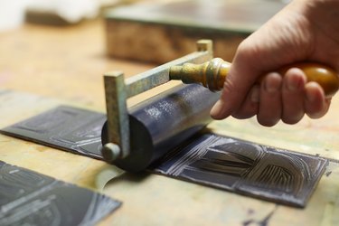 Printmaker inking lino print block