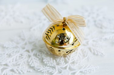 Golden jingle bell Christmas bauble on white