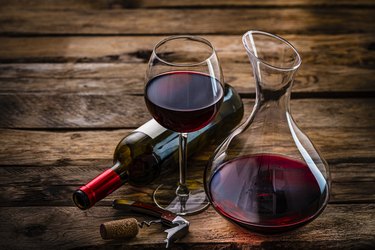 Wineglass wine bottle and decanter on rustic wooden table. Copy space