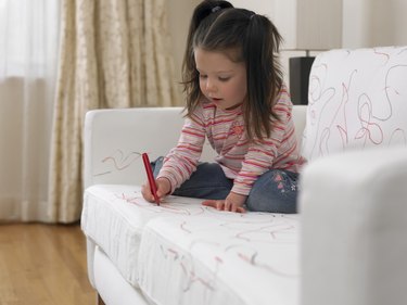 Girl using marker on sofa