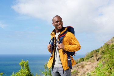 happy african american man with backpack in nature