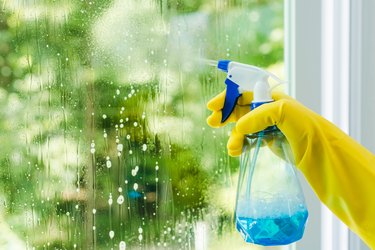 woman spraying and wiping glass