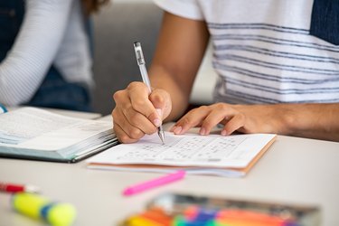 High school student filling out test answers with pen