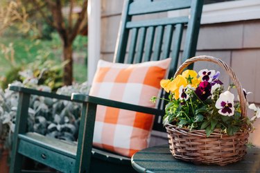 Flower basket next to a green rocking chair