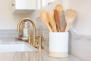 Close-Up Of Wooden Spoons In Container On Kitchen