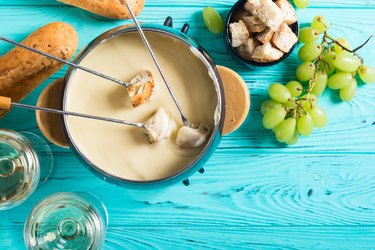 Cheese fondue with bread, wine and grapes