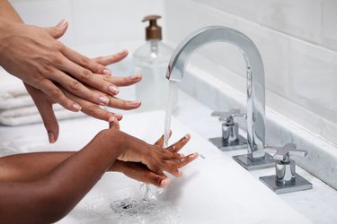 Washing hands at bathroom sink