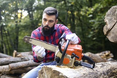 Lumberjack checking his chainsaw