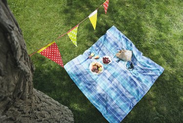 Italy, Tuscany, Picnic blanket with food and flag line above it
